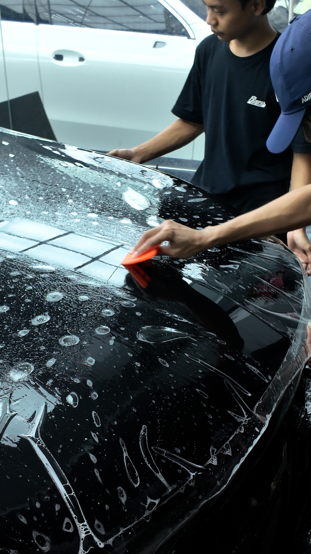 Proses pemasangan PPF mobil pada kap mesin di workshop WRAPEED