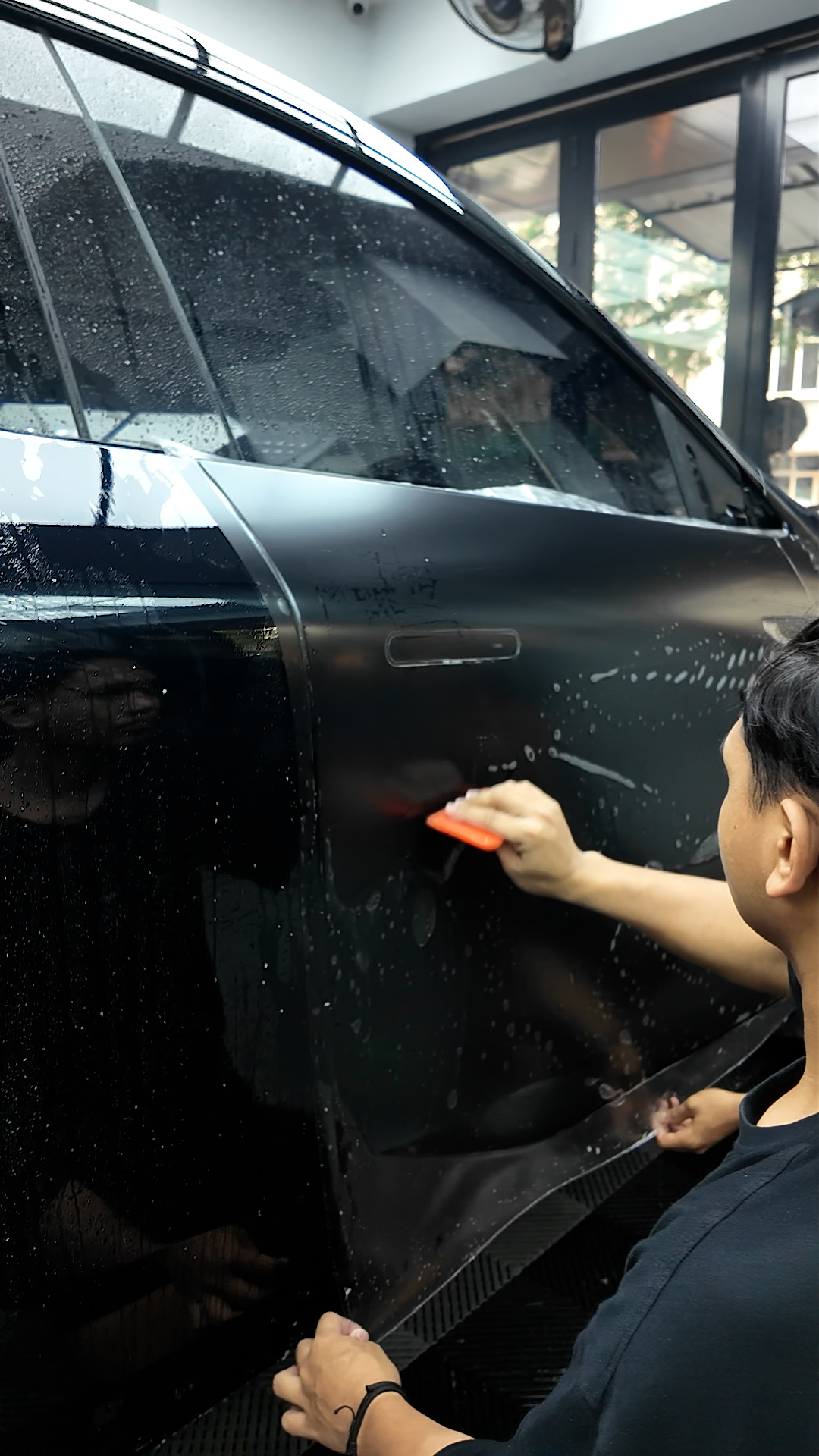 Teknisi memasang PPF matte pada panel pintu mobil di WRAPEED